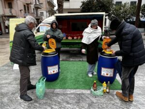 Campagna di sensibilizzazione al mercato settimanale di Grottammare. Due cittadini versano olio vegetale esausto nei due contenitori Olivia.